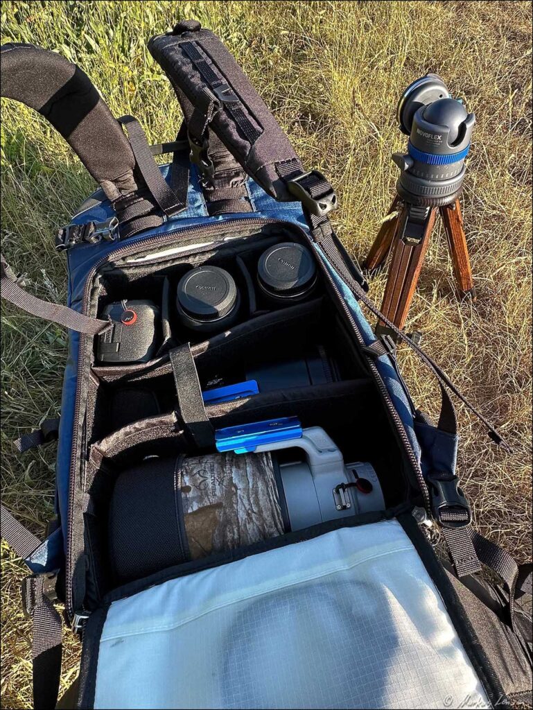 NYA-EVO Rucksack liegt geöffnet in der Sommerwiese